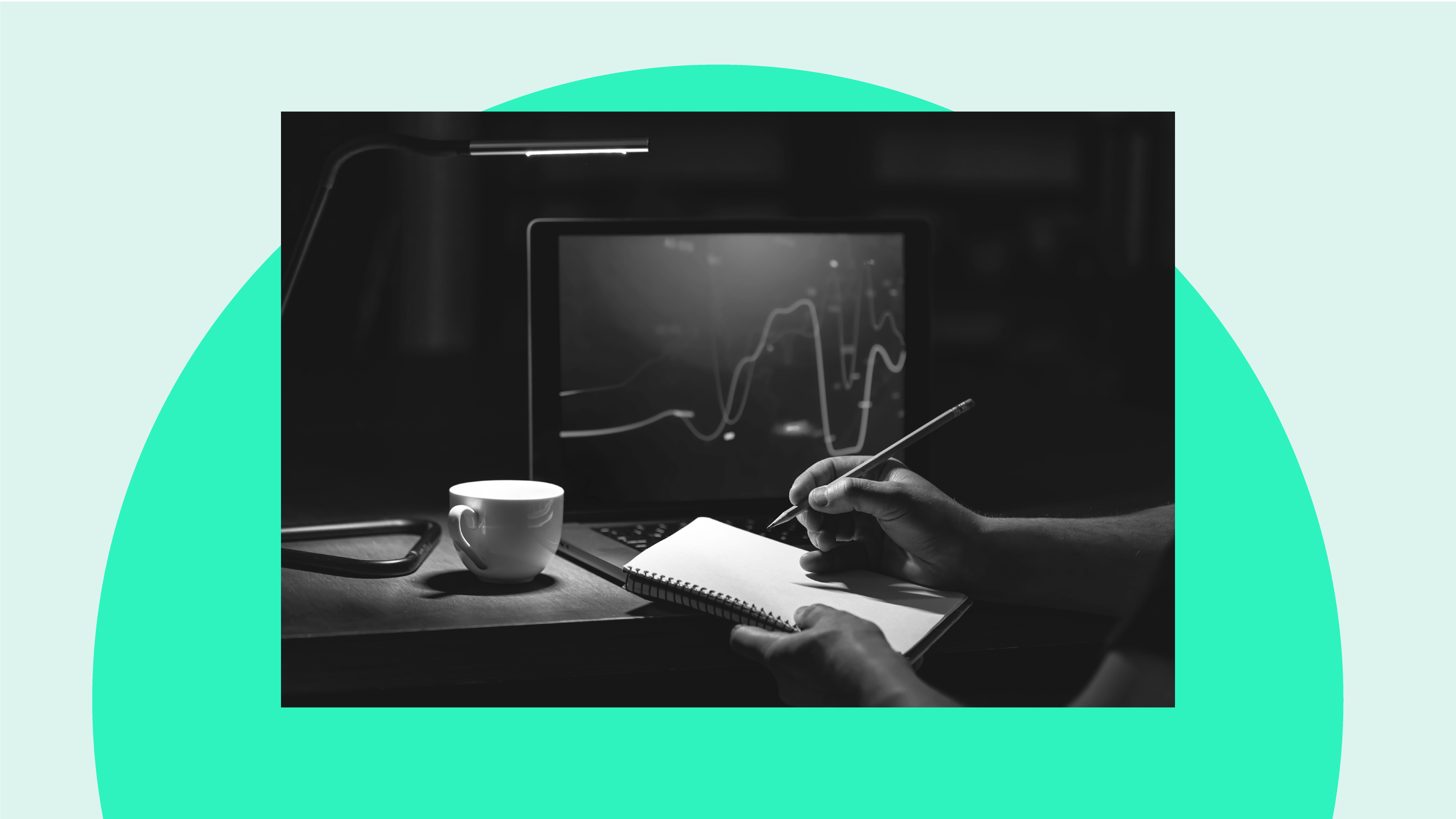Someone with a trading side hustle works out their tax with a pen and paper by a laptop